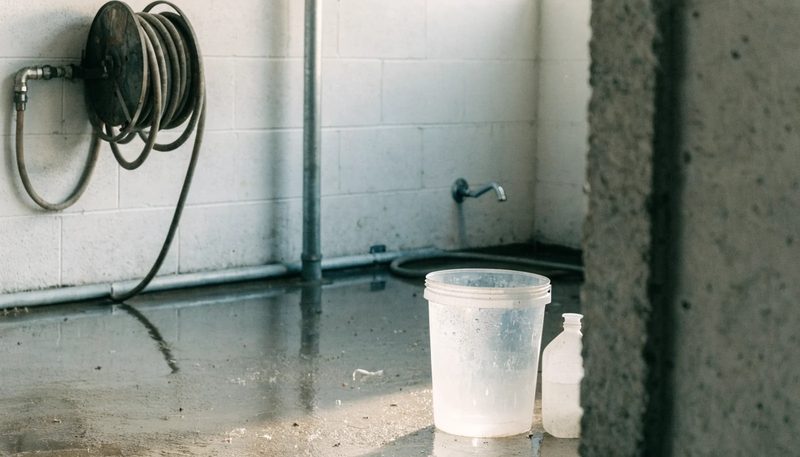 A washdown area in a clean farm building with a coiled hose.