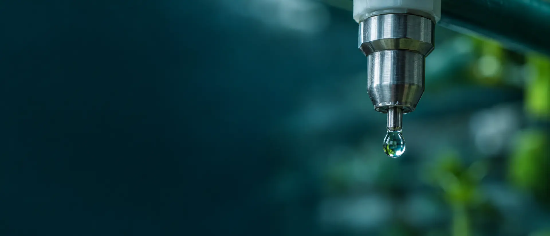 Macro of a stainless nipple drinker with a clear water droplet on its tip