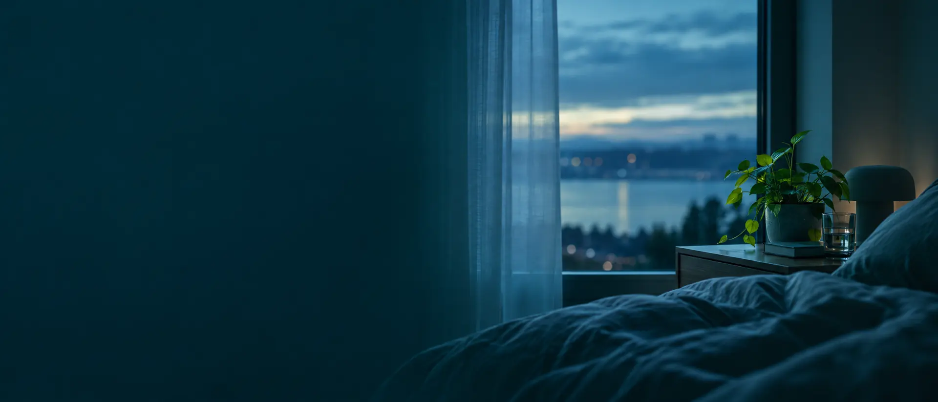 Sheer curtain at a bedroom window at blue hour with a dim horizon